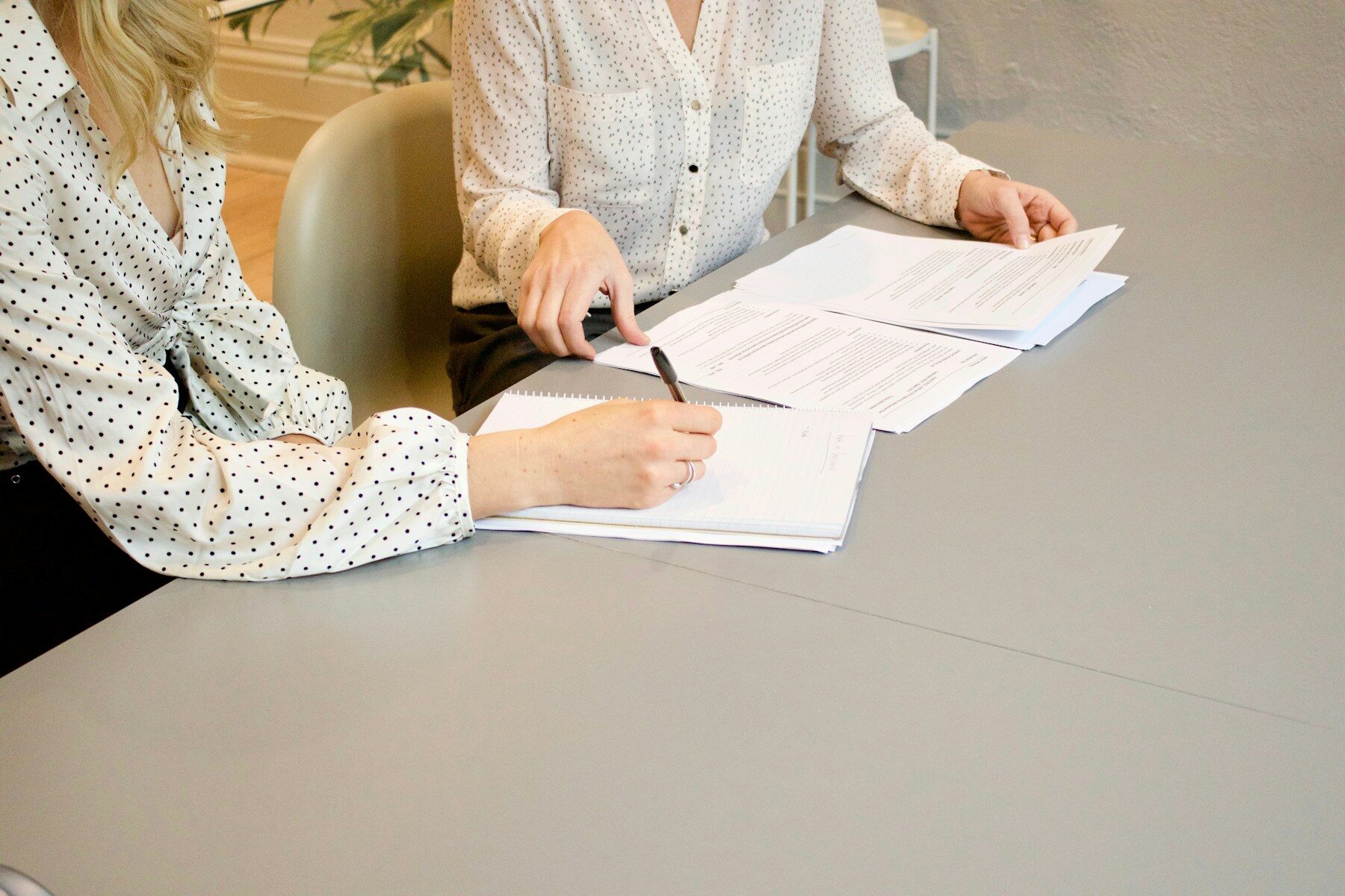 Two people working through enrollment paperwork together at a desk.